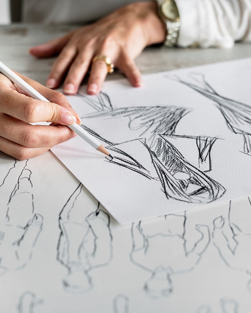 Top view on woman designer drawing clothes sketches